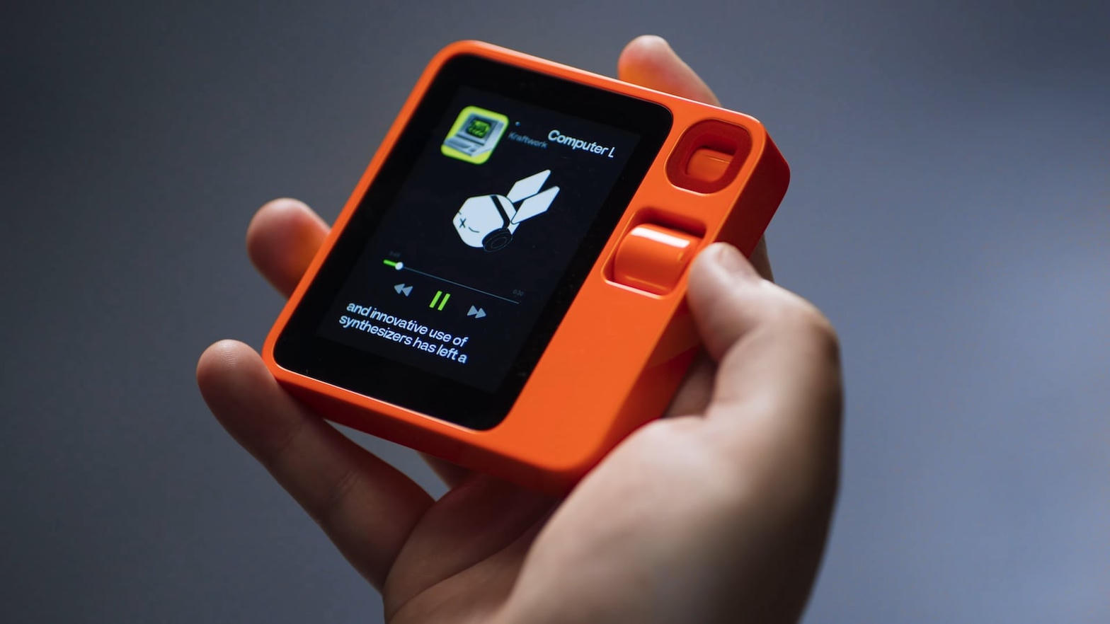 Rabbit R1 handheld close-up showing music interface